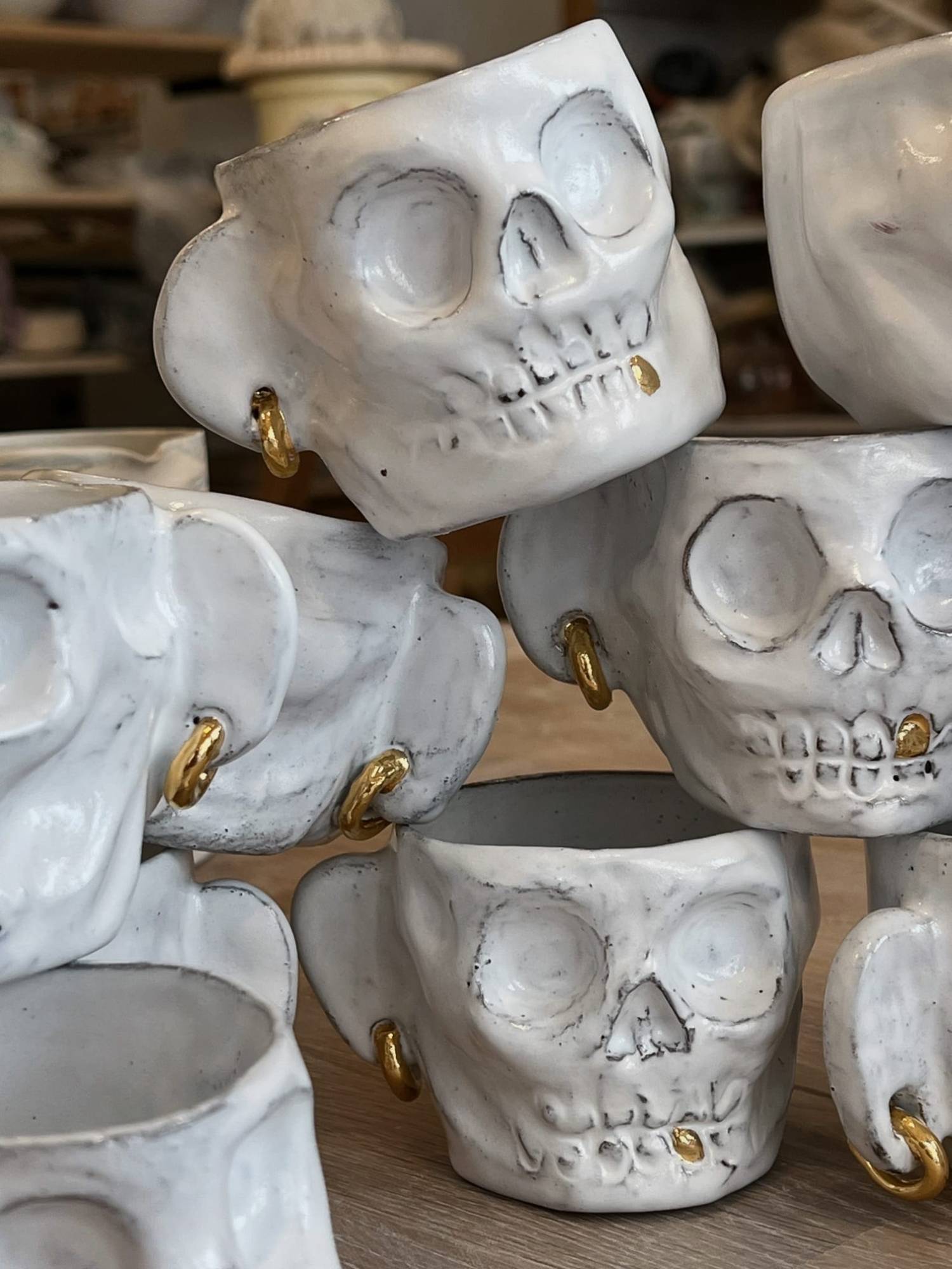 Tasses « Crânes » en faïence, modelées, avec anneaux et dents en lustre or